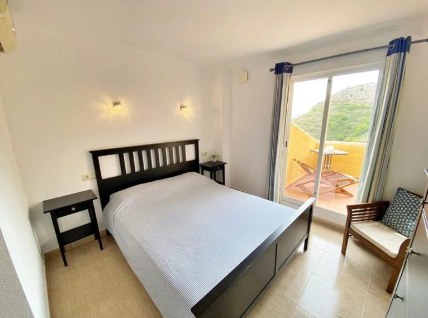 Slaapkamer met tweepersoonsbed en balkondeur