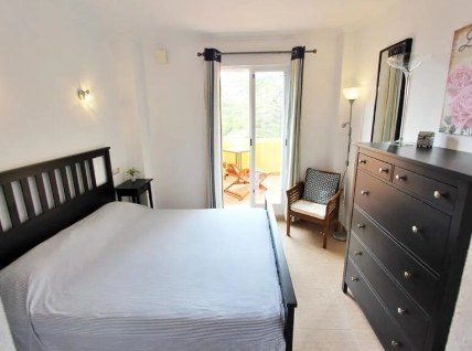 Slaapkamer met tweepersoonsbed en ladekast