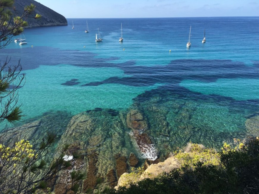 Heldere blauwe baai met zeilboten aan de Costa Blanca